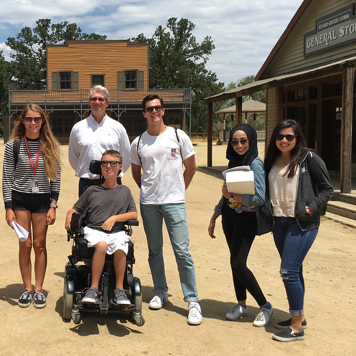 A group of students and their professor in front of a Western-style general store