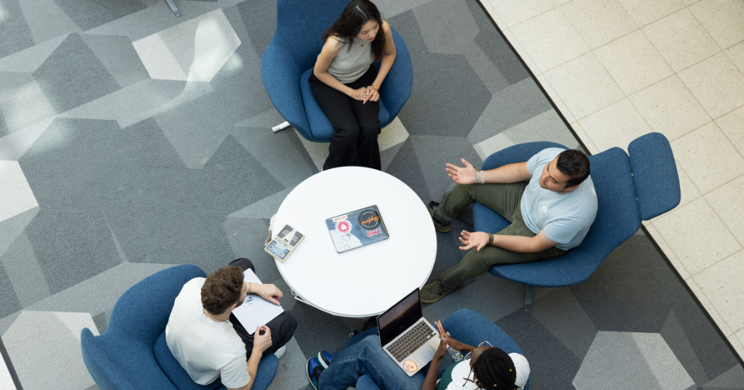 LMU students talk around a table in the Von der Ahe building at LMU